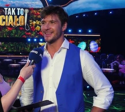 Mikołaj Roznerski z filiżanką kawy, symbolizujący jego markę