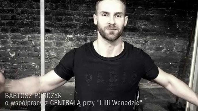 Bartosz Porczyk na scenie teatralnej, w trakcie występu, z dynamicznym oświetleniem i rozmytym tłem scenicznym.