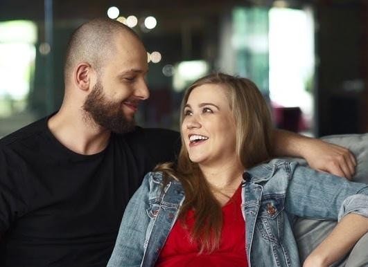 Maciej Pela trzymający smartfon z widoczną aplikacją Instagram, symbolizujący jego aktywność w mediach społecznościowych.