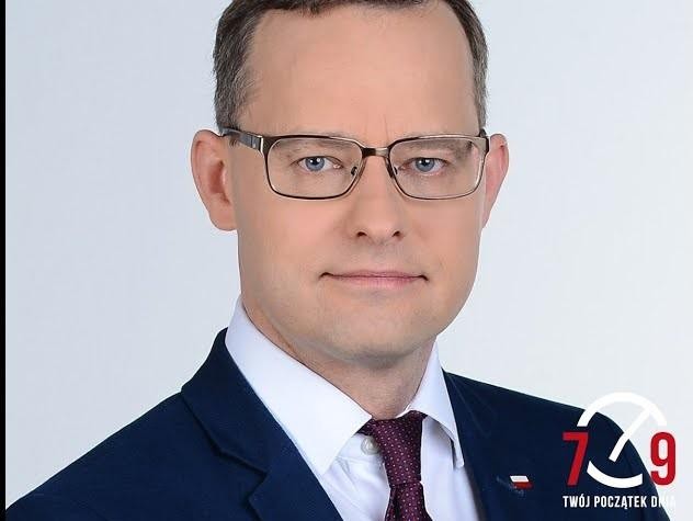 Marcin Romanowski podczas wykonywania obowiązków służbowych, w tle widoczne elementy Ministerstwa Sprawiedliwości lub Sejmu, symbolizujące jego aktywną rolę w polskiej polityce i wymiarze sprawiedliwości.