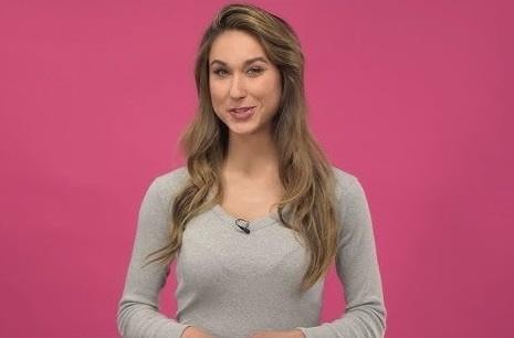 Alt: Ida Nowakowska w dynamicznej pozie podczas występu telewizyjnego, w stylowym stroju, z wyrazistym uśmiechem i scenicznym oświetleniem.