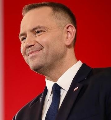 Alt: Karol Nawrocki podczas publicznego wystąpienia, symbolizującego jego zaangażowanie w promowanie historii i pamięci narodowej.