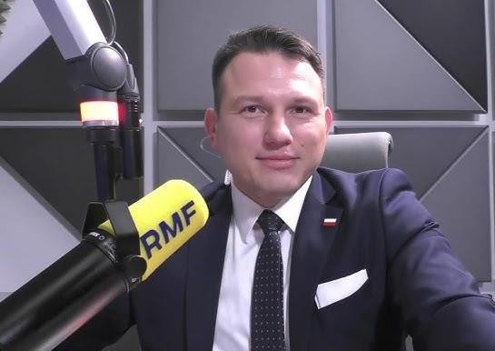 Sławomir Mentzen przemawiający do tłumu, z dynamiczną mimiką, sugerującą energię i charyzmę.