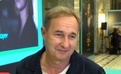 Pusta scena teatralna oświetlona ciepłym światłem, symbolizująca przestrzeń artystycznych kreacji Marka Kality.