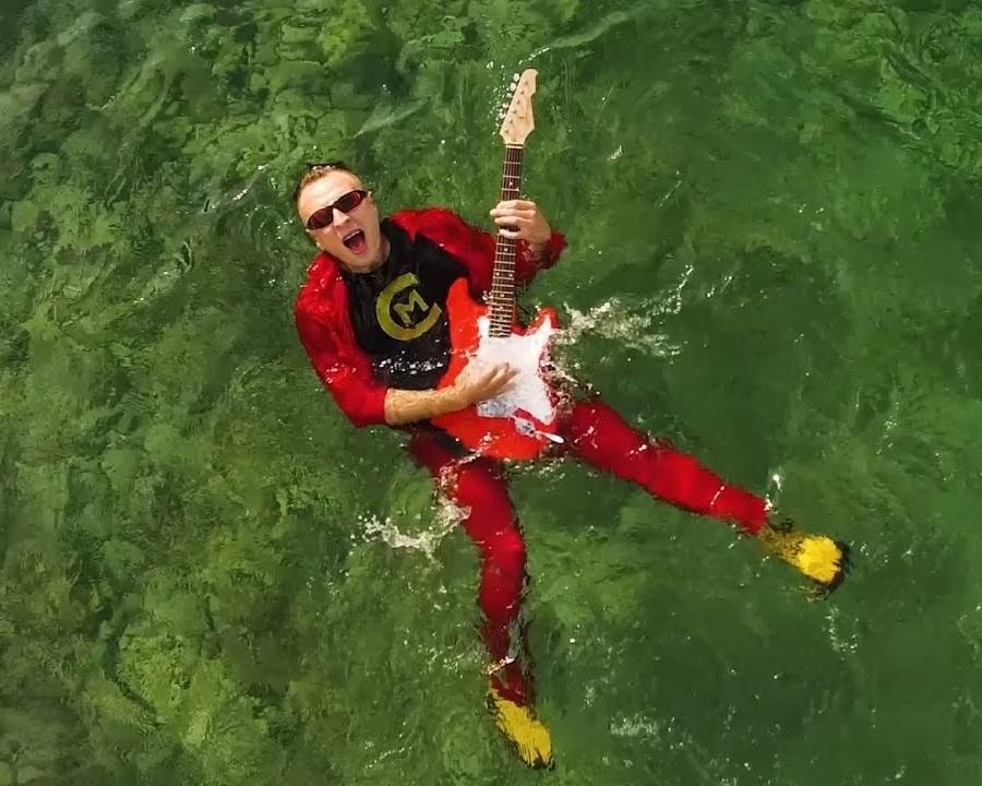 Czadoman podczas energicznego występu na scenie, otoczony światłami dyskotekowymi.