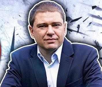 Piotr Szumlewicz przemawiający na publicznym zgromadzeniu, z widocznym zaangażowaniem i gestykulacją, w tle uczestnicy spotkania.