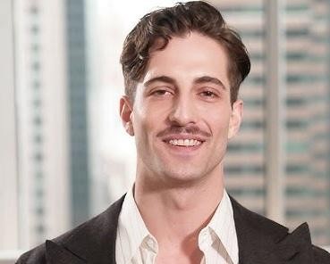 Damiano David podczas solowego występu na scenie, z mikrofonem, w dynamicznej pozie, podświetlony światłami koncertowymi.