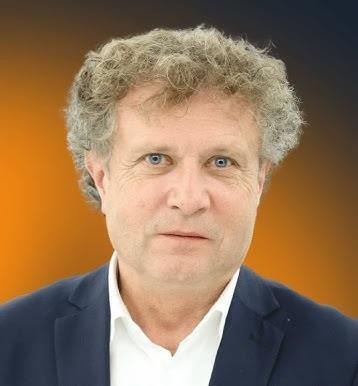 Jacek Karnowski podczas uprawiania jednego ze swoich ulubionych sportów wodnych, np. żeglarstwa, w tle widać morze i niebo.