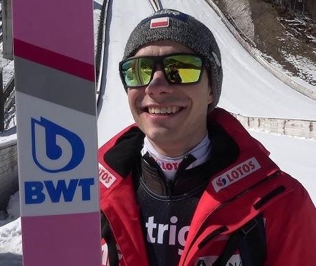 Jakub Wolny na podium z medalem, uśmiechnięty i dumny ze swojego osiągnięcia.